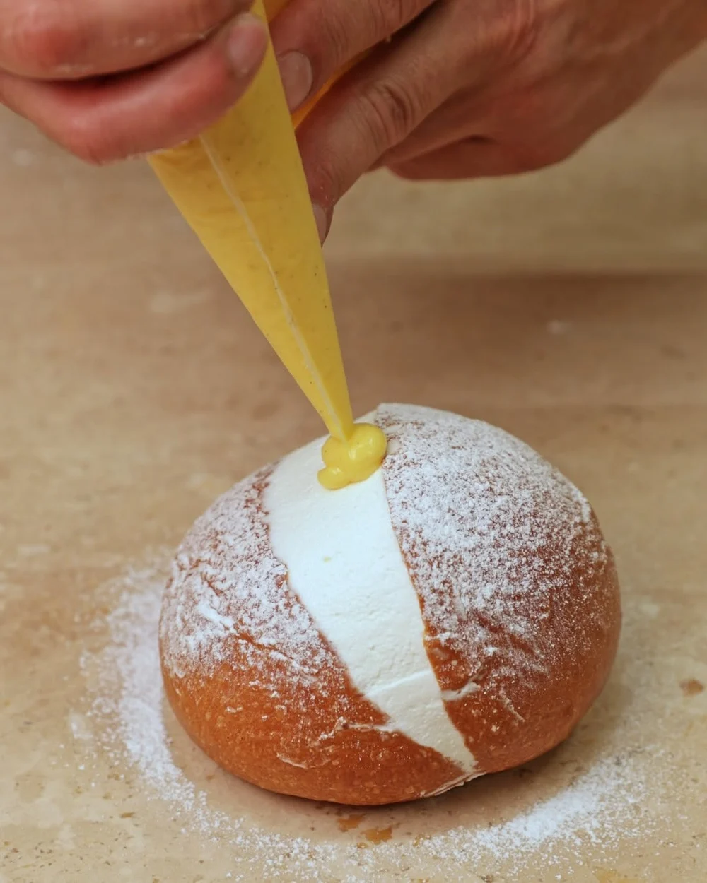 Brioche farcita a mano con panna e crema nel laboratorio di Matrice